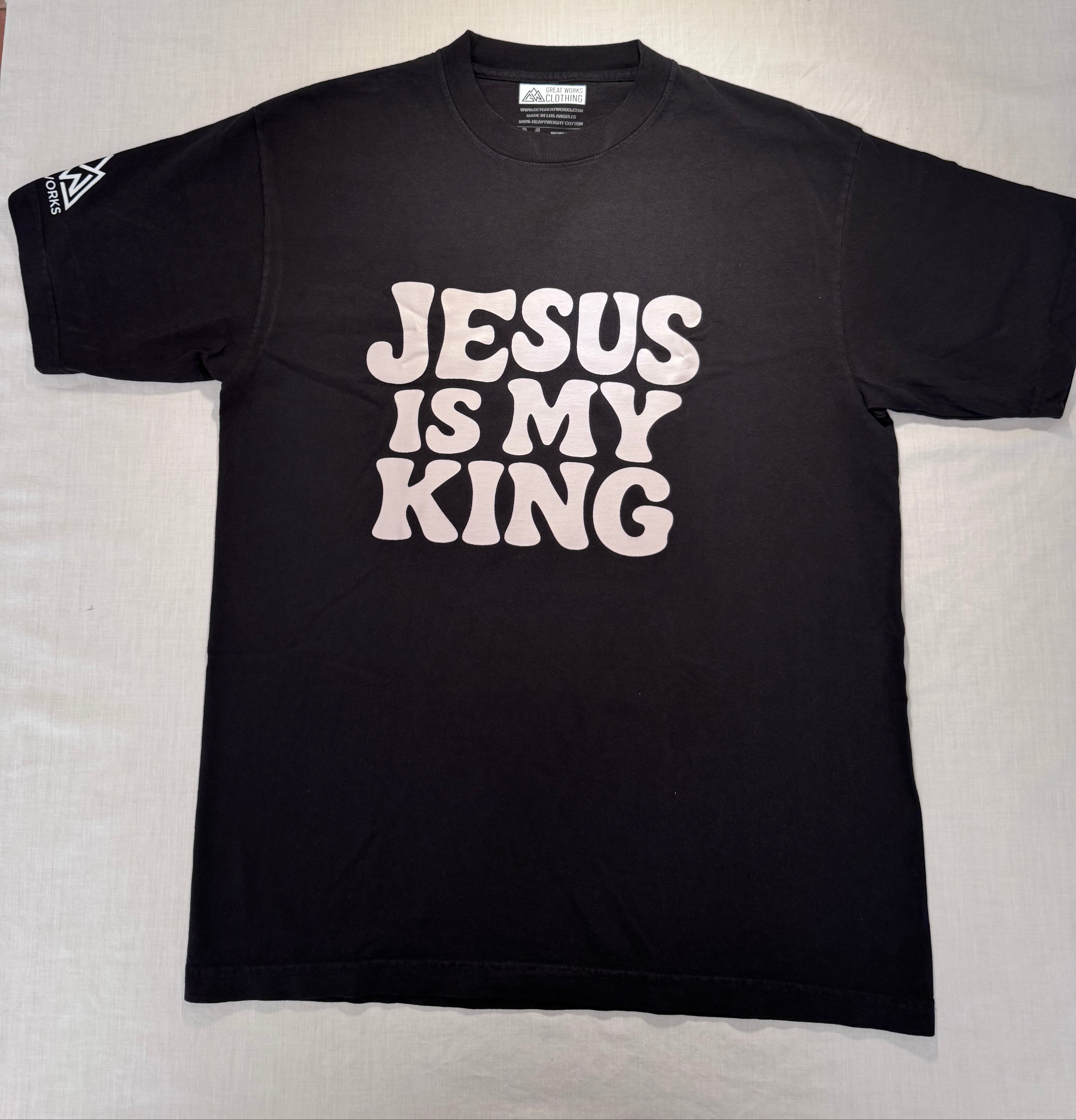 Black t-shirt with 'Jesus is my King' text on a light gray surface