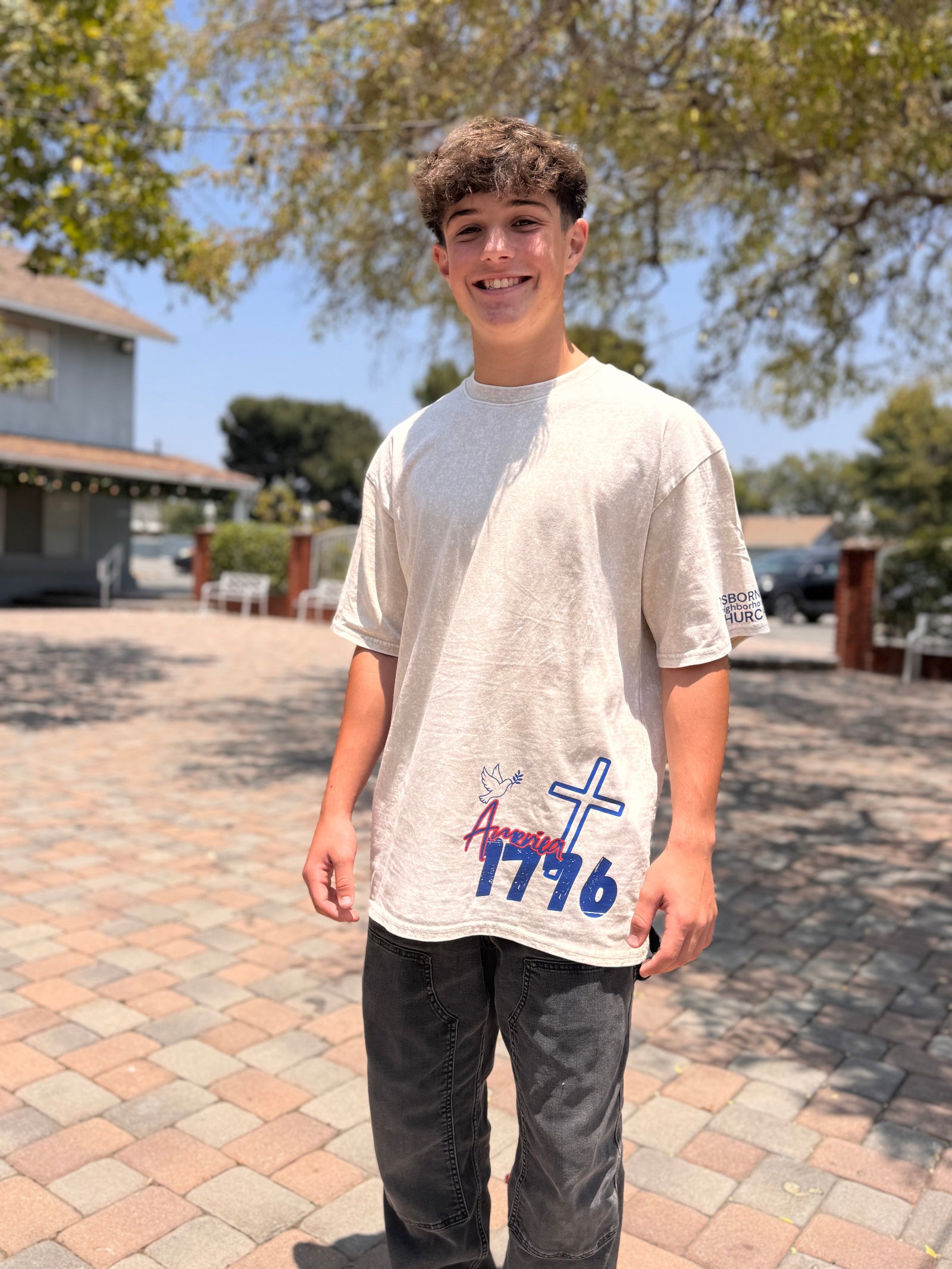 Student smiling while wearing the Osborne Neighborhood Church 250th anniversary custom shirt with America 1776 front design